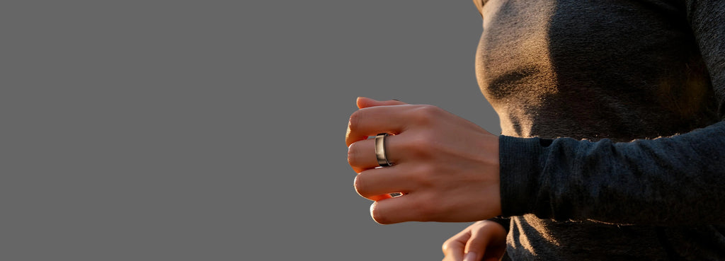 Person holding a ring with a blurred natural background